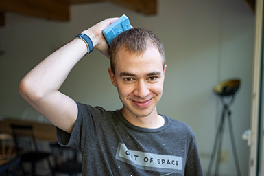 Me, smiling into the camera while holding a cool pack to the back of head